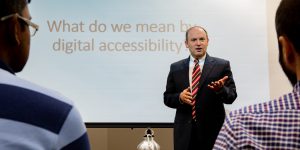 Image of Dr. Jonathan Lazar delivering a lecture on digital accessibility to an audience.