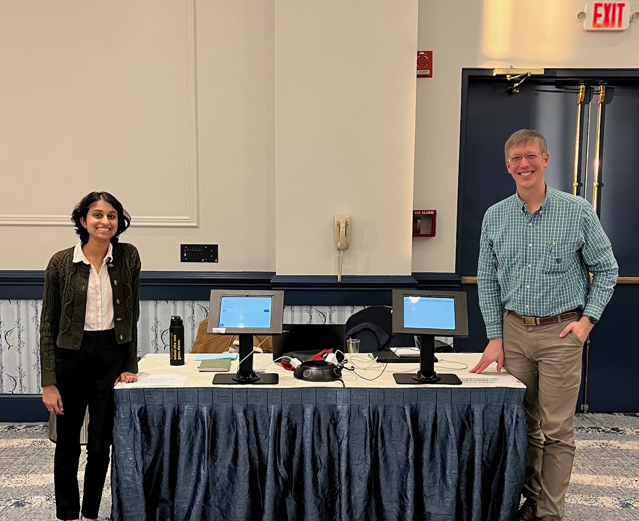 a man and girl stand on opposite sides of a table with two kiosks on it